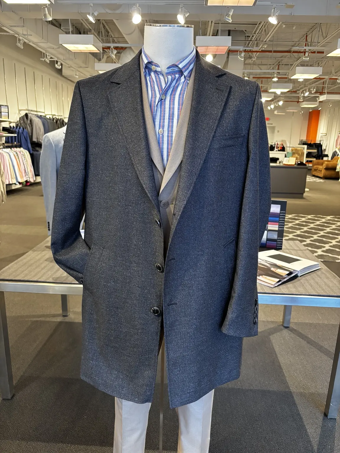 Blue overcoat displayed on a mannequin in the Modern Suit & Dress store