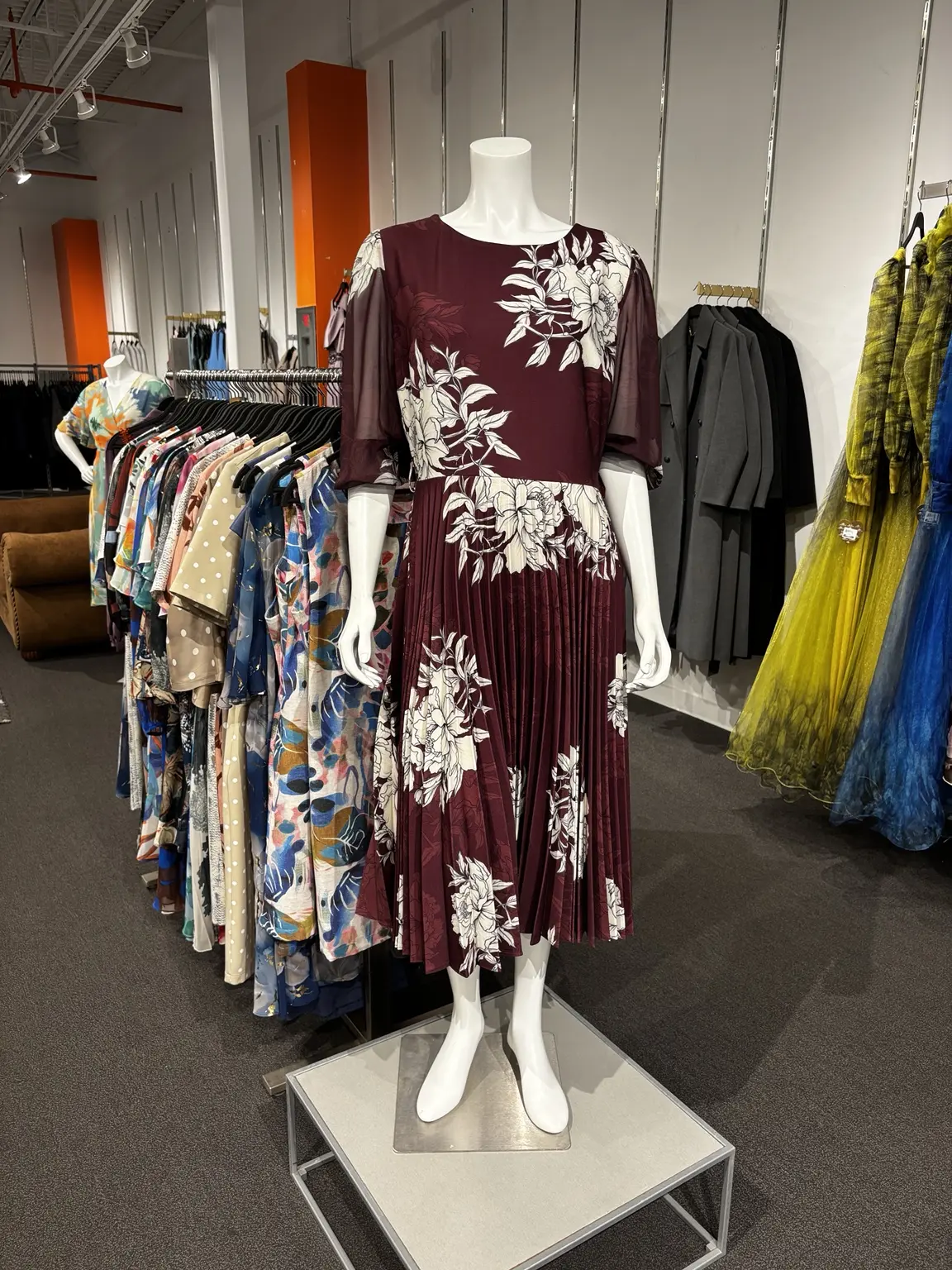 Burgundy floral pleated dress displayed on a mannequin in the Modern Suit & Dress store